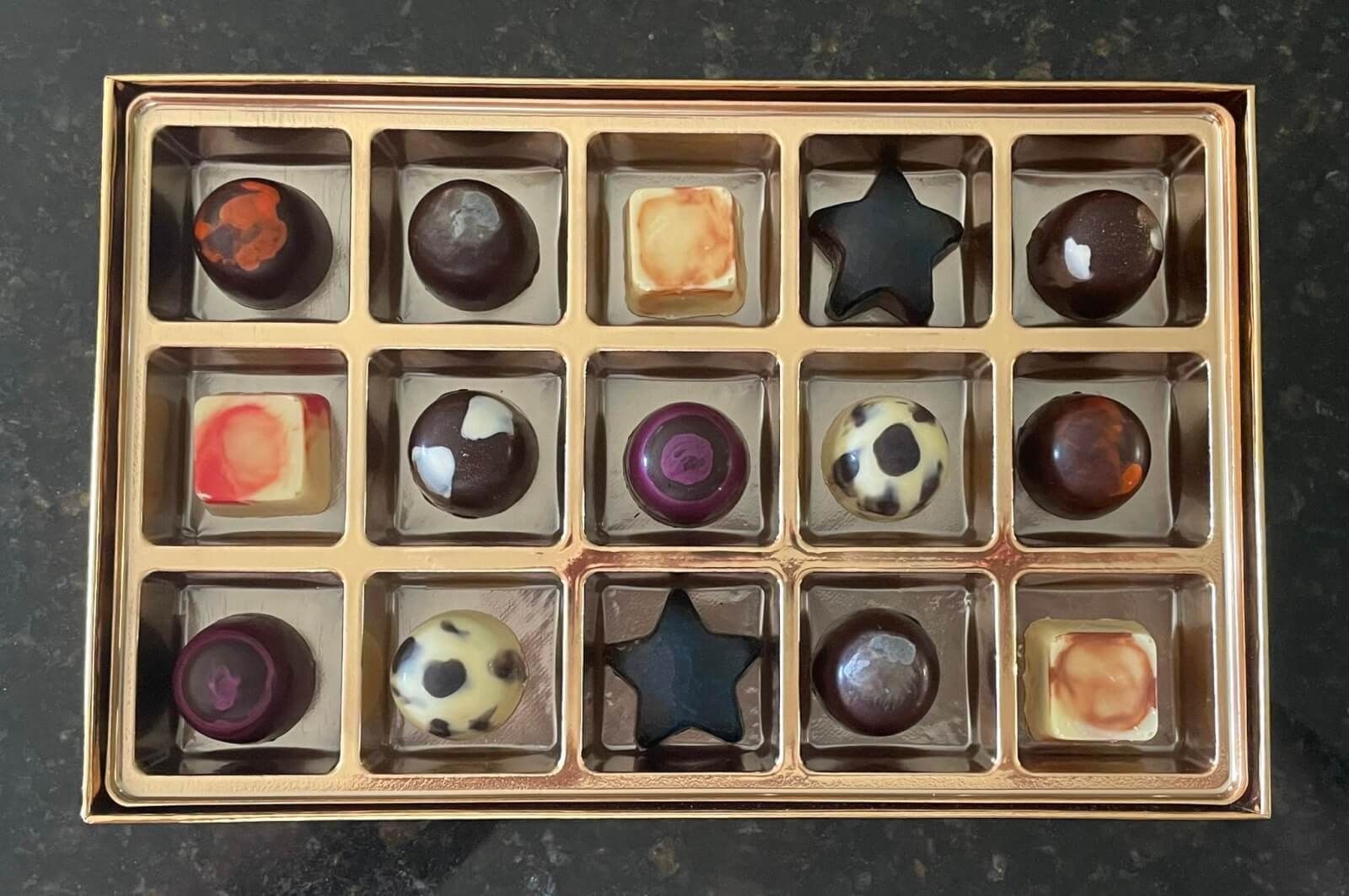 15 assorted chocolate truffles in a gold box from Shug's Baked Goods, LLC, a military-owned small business.