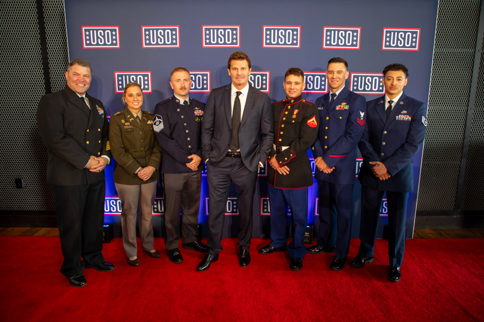 2026 USO Gala with Global Ambassador David Boreanaz and service members in uniform with the USO step and repeat in the background.