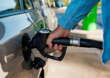 Person fills up car with gas at gas station.