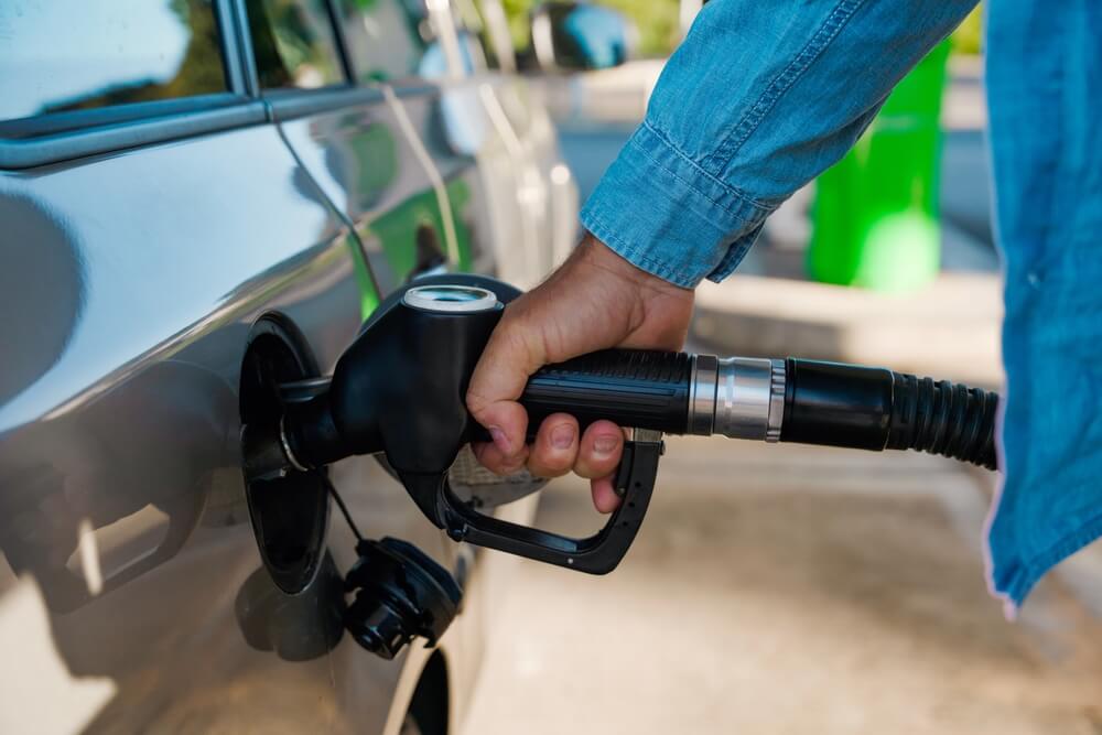 Person fills up car with gas at gas station.