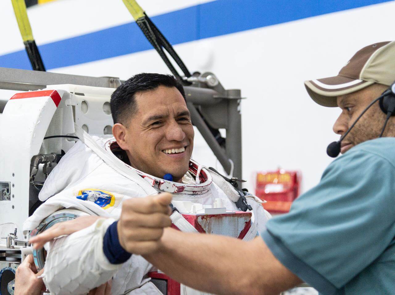 NASA astronaut Frank Rubio being helped into a spacesuit for spacewalk training