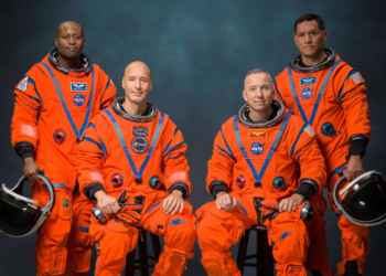Artemis III crew dressed in orange astronaut suits.