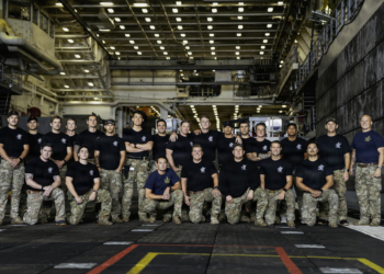 Navy divers and explosive ordnance disposal technicians pose for a group photo ahead of Artemis II recovery operations.