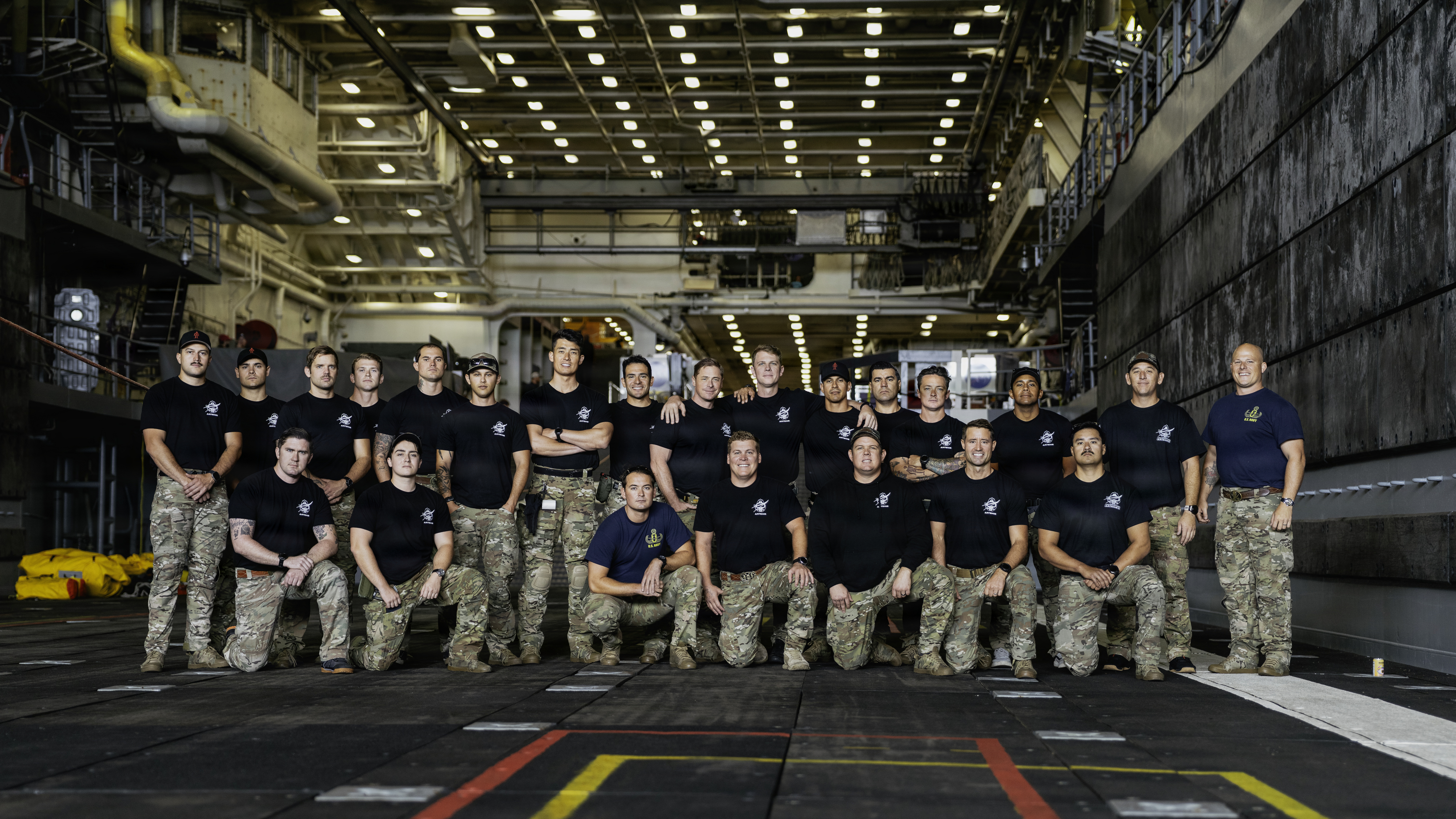 Navy divers and explosive ordnance disposal technicians pose for a group photo ahead of Artemis II recovery operations.
